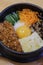 Korean Bibimbap dish with rice and vegetables on wood background