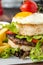 Korean burger with sunny side up egg, rice and fried fries on wooden background