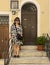 Korean female tourist posing before the entrance to a residence along a street in Montepulciano, Italy.