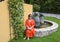 Korean female tourist posing on a Fountain from old devices for manufacturing perfume, Fragonard Parfumeur, Grasse, France