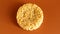 Korean instant noodles in the shape of a circle on a brown background. A yellowish-white dried raw vermicelli with long round