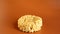 Korean instant noodles in the shape of a circle on a brown background. A yellowish-white dried raw vermicelli with long round