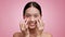 Korean Lady Applying Patches Under Eyes Moisturizing Skin, Pink Background