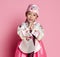 Korean little baby girl in traditional silk dress for new year celebration on pink with hands in pray sign