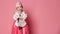 Korean little baby girl in traditional silk dress for new year celebration on pink with hands in pray sign