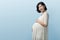 Korean pregnant woman standing on Blue background