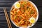 Korean Rabokki is what happens when you mix tteokbokki with ramen noodles closeup in the bowl. horizontal top view