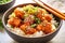 Korean style cauliflower with sour sweet spicy sauce and sesame and rice in a bowl. Delicious vegan dish. Healthy plant based diet