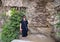 Korean tourist among stone architectural elements and gardens in Park Guell in Barcelona, Spain.