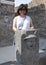 Korean woman on holiday behind a public water drinking fountain, Scavi Di Pompei