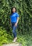 Korean woman participating in a family vacation photoshoot posing in front of a dense wall of ivy in Bar Harbor, Maine.