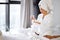 korean woman taking a pill, sitting on her bed at home, wearing bathrobe and towel