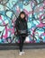 Korean woman on walking tour in front of unsigned wall mural in the Italian Market, South Philadelphia, Pennsylvania