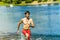 Korean young man running on water with a smile and a naked torso