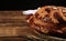 Korovai with wheat spikes on wooden table against black background, space for text. Ukrainian bread and salt welcoming tradition