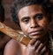 Korowai tribe woman with the necklace around the neck of a wild boar teeth. Tribe of Korowai.