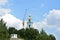 The Kostroma Kremlin is under construction. A construction crane is erecting a bell tower. Blue sky