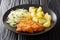 Kotlet Schabowy is a Polish pork schnitzel covered with breadcrumbs served with potatoes and fresh salad closeup in the plate.