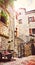 Kotor narrow small streets of historical old town. House drying linen bright sun blind old stone. Authentic structures. No body to