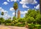 Koutoubia Mosque minaret at medina quarter of Marrakesh, Morocco. There is beautiful green garden with palms. Blue sky is in the