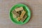 Kozinaki with seeds, nuts, sesame seeds with honey in a green plate, on a brown mat. Useful snacks. Fitness nutrition, nutritious