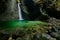 Kozjak Waterfalls, Kobarid, Julian Alps, Slovenia in Europe. Green lake surface in rock gorge, big wet stones in the foreground. W