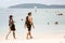 Krabi, Thailand - February 12, 2019: A guy and a girl heavily covered with tattoos are walking on a tropical sandy beach. Tattooed
