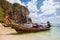 Krabi, Thailand - February 12, 2019: Taxi boats moored on the sandy Phra Nang beach. View on longtail boats, cave and rocks in