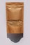 Kraft paper pouch bag with whole grain brown rice top view with harsh shadow white background. Healthy diet cereal food