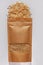 Kraft paper pouch bag with whole grain brown rice top view with harsh shadow white background. Healthy diet cereal food