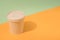 Kraft paper street food container or cup with paper cap on orange and green background