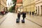 Krakow, Poland - 5 7 2019. A young couple will ride down the street of the old town with tourist suitcases on wheels. Grodskaya