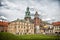 Krakow, Poland - June 04, 2017: Wawel cathedral with chapels on green hill. Tourists at catholic church on cloudy sky. Architectur