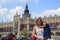 Krakow, Poland - June 11, 2018: Beautiful girl holding tired daughter in market  square of Krakow. concept of traveling with kids