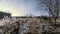 Krakow, Poland: Meadow against sunset in an open children park and an unidentified kid swinging in a distance during winter