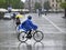 Krakow resident rides a bicycle in heavy rain, Poland