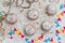 Krapfen, Berliner or donuts with streamers, confetti and mini marshmallows on white wooden background