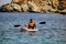 Kreta or Crete  Greece - A man in life jacket floating on a kayak in a sea against blurred rocky mountain in the background. Water