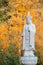 Ksitigarbha Buddha, a Bodhisattva, statue with yellow fall colors in the background