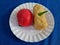 Ku cake and rissoles in a white container on a blue cloth background