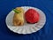 Ku cake and rissoles in a white container on a blue cloth background