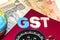 Kuala Lumpur, Malaysia-December 2,2017 : Closeup of GST words with globe, compass and Rupee notes. Selective focus and crop fragme