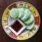 Kuih Lopes and syrup on a round plate. Square photo image.