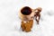 Kuksa with tea and gingerbread cookies in the snow. Finnish traditional wooden cup.