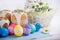 Kulich, Russian Ukrainian Easter cake with colored eggs lace ribbon on white wooden background