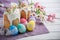 Kulich, traditional Russian Ukrainian Easter cake with icing and colored eggs with lace ribbon on white wooden background