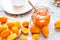 Kumquat on plate and jam in jar at gray background