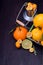 Kumquats, mandarins, lemons and limes against dark background