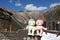 Kuppa dolls sitting on the timber signage with Kuppa bridge and beautiful Kamikochi mountain background