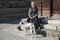 KURASHIKI, JAPAN - MARCH 31, 2019: Japanese man with a dog breed Dalmatian resting on the steps near the house